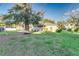 Backyard featuring a house, shed, lush grass, and mature trees at 1495 Davis Ave, Bartow, FL 33830