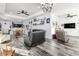 Bright living room featuring modern wood-look flooring and an open floor plan to the kitchen and dining area at 1495 Davis Ave, Bartow, FL 33830