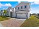 Two-story house with gray siding, a two-car garage, and a stone paved driveway at 171 Golden Noble St, Kissimmee, FL 34747