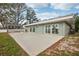 Concrete patio with access to the home through multiple sliding glass doors offering views of the lush backyard at 20 N Lake Idylwild Dr, Winter Haven, FL 33881