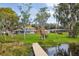 Expansive backyard leading to waterfront, complemented by lush greenery, trees, and a private dock at 20 N Lake Idylwild Dr, Winter Haven, FL 33881