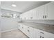 Well-lit kitchen featuring white cabinetry, granite counters, tile backsplash, and a window at 20 N Lake Idylwild Dr, Winter Haven, FL 33881