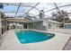 A sparkling in-ground pool surrounded by a screened enclosure and back exterior of the home at 20 N Lake Idylwild Dr, Winter Haven, FL 33881