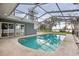 A sparkling in-ground pool surrounded by a screened enclosure and back exterior of the home at 20 N Lake Idylwild Dr, Winter Haven, FL 33881