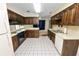 Galley-style kitchen with dark wood cabinets and tile floors at 2004 Varner Cir, Winter Haven, FL 33884