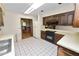 View of kitchen with dark wood cabinets and tile flooring at 2004 Varner Cir, Winter Haven, FL 33884