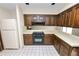 Kitchen features dark wood cabinets, tile floors, and appliances at 2004 Varner Cir, Winter Haven, FL 33884