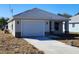 Charming single-story home featuring a two-car garage, gray roof, and neutral stucco exterior at 2013 Alderman Rd, Auburndale, FL 33823