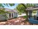 Private backyard patio with red brick, detached garage, and a pergola-covered walkway at 2016 Seminole Trl, Lakeland, FL 33803