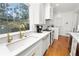 White kitchen with farmhouse sink, gold fixtures, and hardwood floors at 2016 Seminole Trl, Lakeland, FL 33803