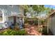 Side porch and backyard featuring red brick patio and mature landscaping at 2016 Seminole Trl, Lakeland, FL 33803