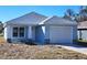 Newly constructed home with light blue exterior, attached garage, and landscaping at 2021 Alderman Rd, Auburndale, FL 33823