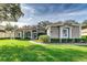 House exterior features a light brown color, manicured lawn, and walkway at 3116 Hawks Ridge Dr, Lakeland, FL 33810