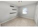 Small bedroom with floating shelves, window with blinds, and tile flooring at 345 Piedmont Ct, Bartow, FL 33830