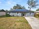 Gray house with solar panels, white shutters, and a paved driveway at 345 Piedmont Ct, Bartow, FL 33830