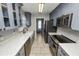 Modern kitchen with gray cabinets, farmhouse sink, and stainless steel appliances at 345 Piedmont Ct, Bartow, FL 33830