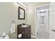 Bathroom with dark vanity, mirror, and hallway view at 3457 Christina Groves Ln, Lakeland, FL 33813