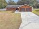 Orange house with two-car garage and long driveway at 3457 Christina Groves Ln, Lakeland, FL 33813