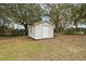 Small beige shed in the backyard with grassy area at 3457 Christina Groves Ln, Lakeland, FL 33813