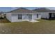 View of backyard with an open grassy area, a concrete patio, and a sliding glass door leading inside at 34575 Shellback St, Leesburg, FL 34788