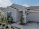 Inviting home with a light gray facade and a two-car garage, creating a welcoming curb appeal at 34575 Shellback St, Leesburg, FL 34788