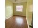 Bright bedroom with wood-look floors and a window at 3638 W Wheeler Rd, Lakeland, FL 33810