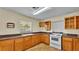 View of kitchen with wood cabinets and white appliances at 470 Lucille St, Bartow, FL 33830