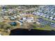 A high angle aerial of the community and clubhouse with tennis courts and lake access on a sunny day at 4938 Deerwood Dr, Lakeland, FL 33810