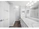 Bathroom with marbled counters, white cabinets and large vanity mirror at 4938 Deerwood Dr, Lakeland, FL 33810