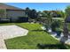 Manicured backyard with well-kept lawn, brick patio, and decorative potted plants along the black metal fence at 516 Homecoming Way, Polk City, FL 33868