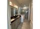 Bathroom with dark granite countertops, gray cabinets, and a glass shower at 516 Homecoming Way, Polk City, FL 33868