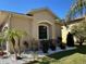 Exterior elevation showcasing stucco wall detail, well maintained lawn and tropical landscaping at 516 Homecoming Way, Polk City, FL 33868