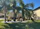 Landscaped front yard featuring palm trees, colorful plants, and white rock ground cover at 516 Homecoming Way, Polk City, FL 33868