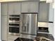 Stainless steel appliances and gray cabinets in kitchen at 516 Homecoming Way, Polk City, FL 33868