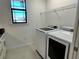 Bright laundry room with white cabinets and a large window at 516 Homecoming Way, Polk City, FL 33868