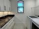 Laundry room with white cabinets, granite countertops, and new washer/dryer at 516 Homecoming Way, Polk City, FL 33868