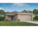 One-story house with beige exterior, gray door, and two-car garage at 5536 Maddie Dr, Haines City, FL 33844