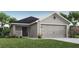 One story home with gray exterior, two car garage, and landscaping at 5544 Maddie Dr, Haines City, FL 33844