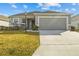 Single-story house with gray siding, two-car garage, and landscaped yard at 6046 Eagle Pointe Dr, Lakeland, FL 33812