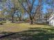 Large backyard with mature trees and grassy area at 702 Nw 1St Ave, Mulberry, FL 33860