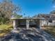 View of the house's carport, with a gate to the backyard at 702 Nw 1St Ave, Mulberry, FL 33860