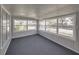 Bright sunroom with gray carpeting and multiple windows at 702 Nw 1St Ave, Mulberry, FL 33860