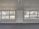 Sunroom with gray carpet, windows, and white door at 702 Nw 1St Ave, Mulberry, FL 33860