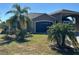 Tan house with palm trees and landscaped yard at 708 Teaberry Trl, Polk City, FL 33868