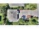 An overhead view shows the house's roof, a stone driveway, and verdant landscaping at 751 Meandering Way, Polk City, FL 33868