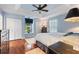 Light blue bedroom featuring a ceiling fan, a window seat and hardwood floors at 751 Meandering Way, Polk City, FL 33868