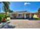 Charming single-story home with blue doors and a brick-paved driveway, surrounded by lush landscaping at 751 Meandering Way, Polk City, FL 33868