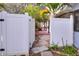 White vinyl fence gate opening to a brick paved pathway at 813 Heron Pl, Winter Haven, FL 33884