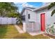 Landscaped backyard with a red door and white fence at 813 Heron Pl, Winter Haven, FL 33884