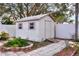 White shed with a ramp and surrounded by landscaping at 813 Heron Pl, Winter Haven, FL 33884